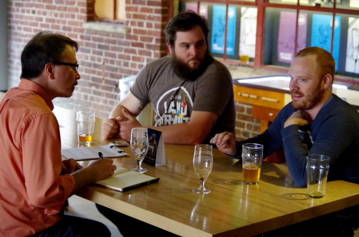 Co-owners Walt Keys (middle) and Adam Benner (right) recalling details of the twists and turns in the birth of Land Grant Brewing.